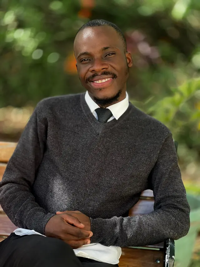 Paddy Daniel smiling in a grey sweater outdoors