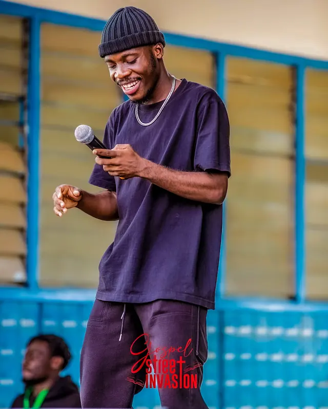 Paddy Daniel smiling with a microphone at an outdoor stage