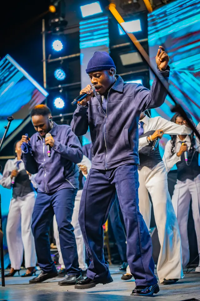 Paddy Daniel and a choir in white performing on stage