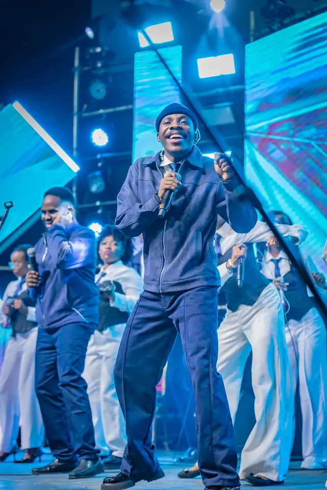 Paddy Daniel leading a choir in a wide stage shot