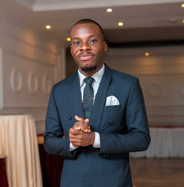Paddy Daniel in a navy suit with a pocket square