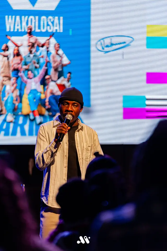 Paddy Daniel singing in front of a colourful festival screen